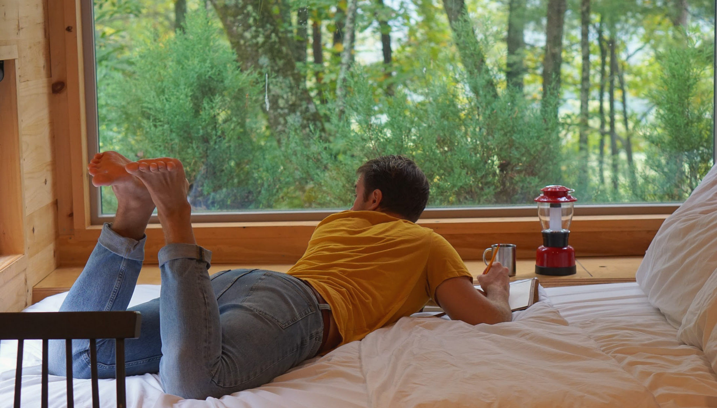 Journaling in the woods inside a tiny getaway cabin