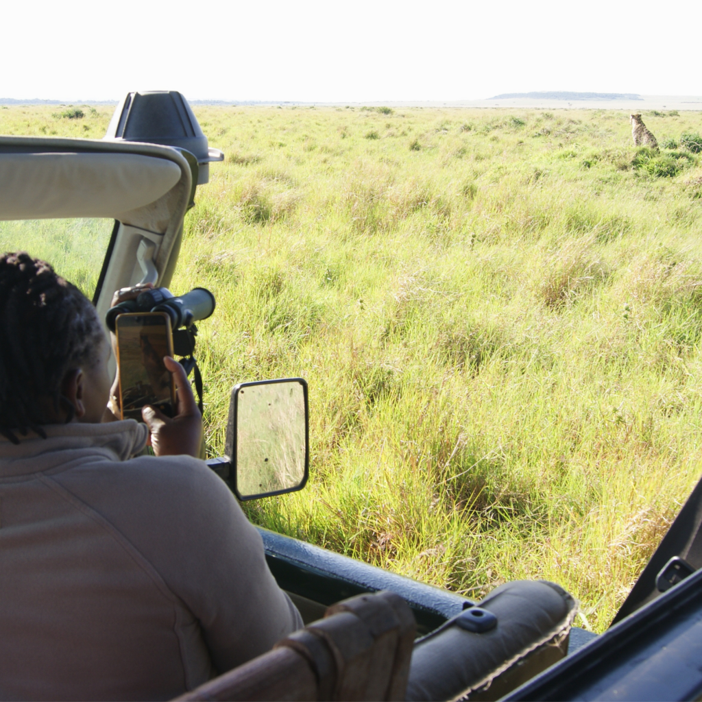 Female safari guide showing guests how to use our binoculars and cell phones to get the perfect video of our leopard sighting.