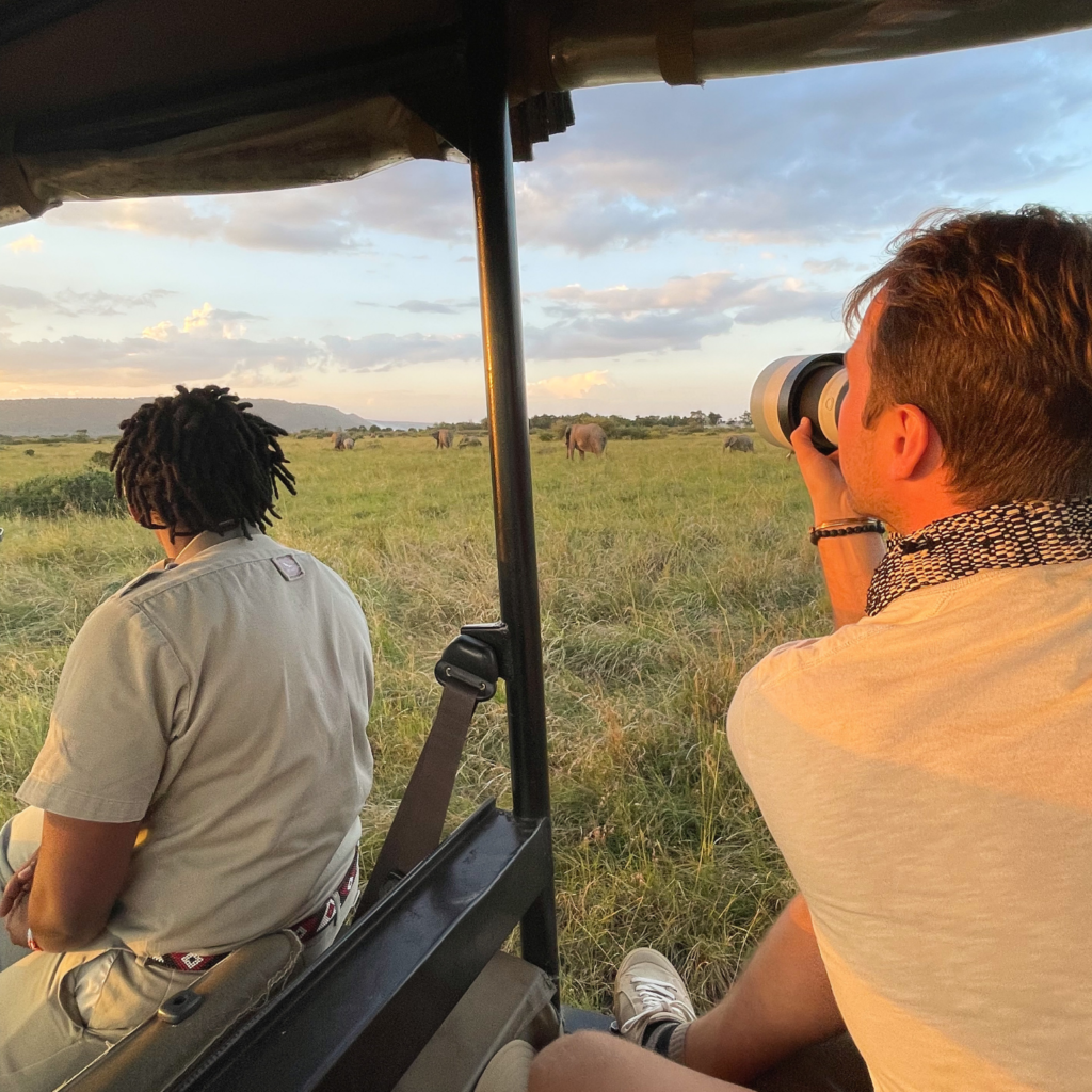 Female safari guide and guest watching elephants